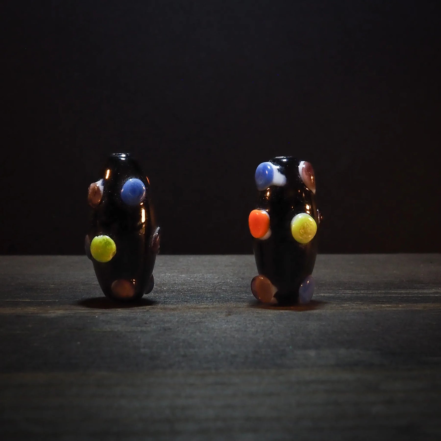 Dark bead with dots in bright colors