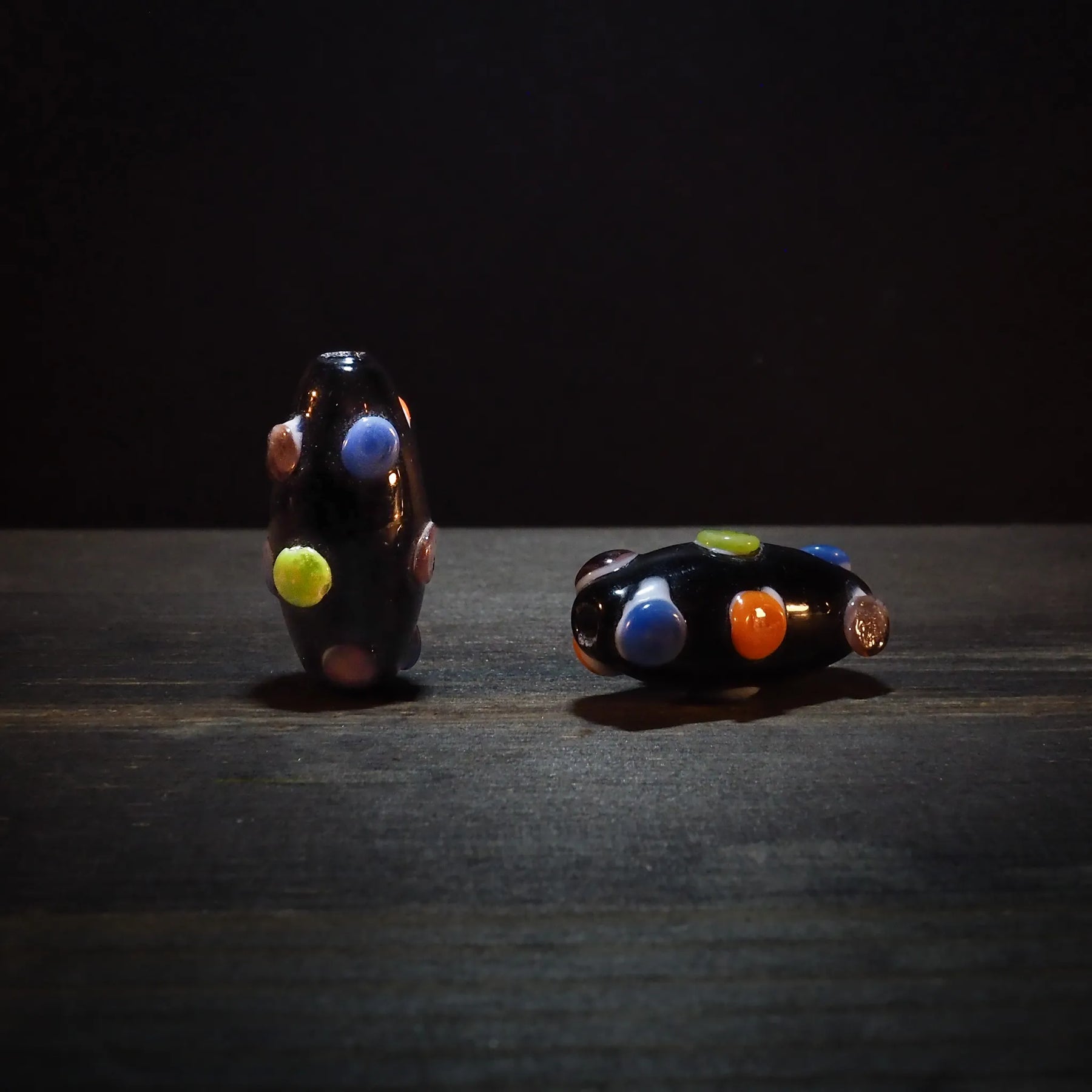 Dark bead with dots in bright colors