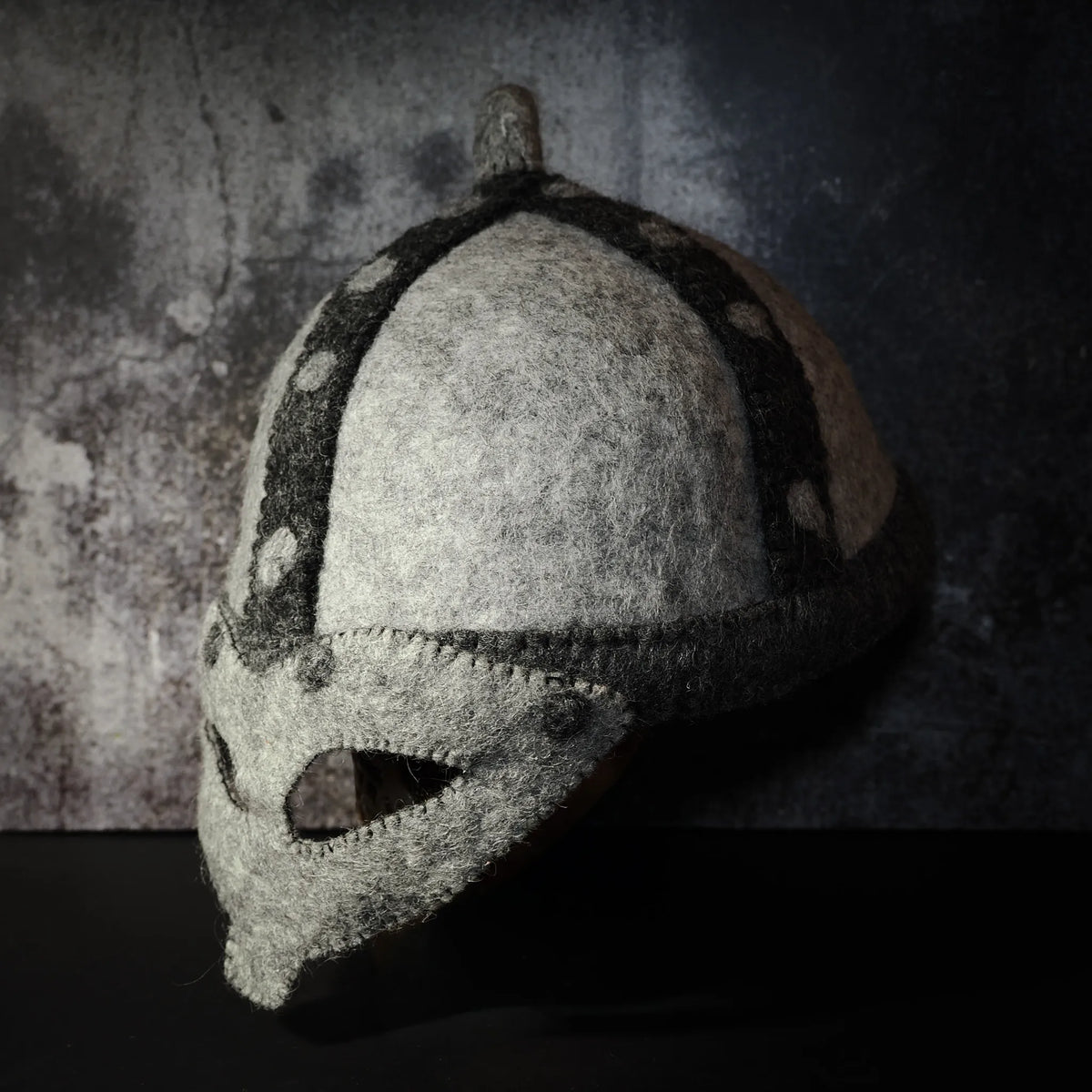 Felted wool helmet side profile view — shows dome shape and structural detail around lower edge