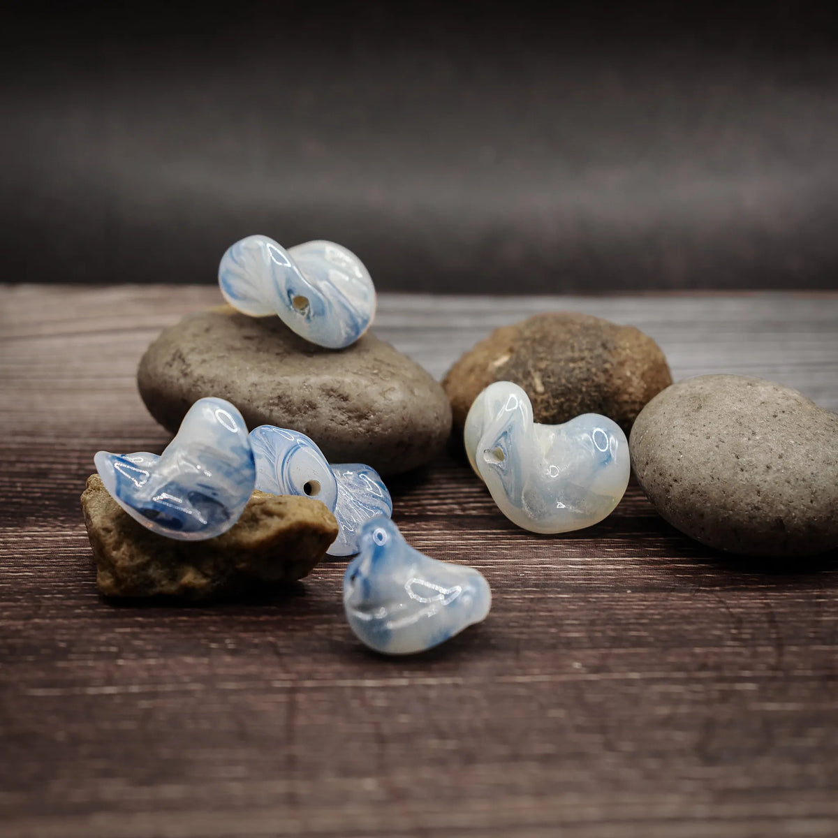 White and blue glass bead in a folded/flat shape – blue swirls in transparent white glass, approx. 15 mm diameter
