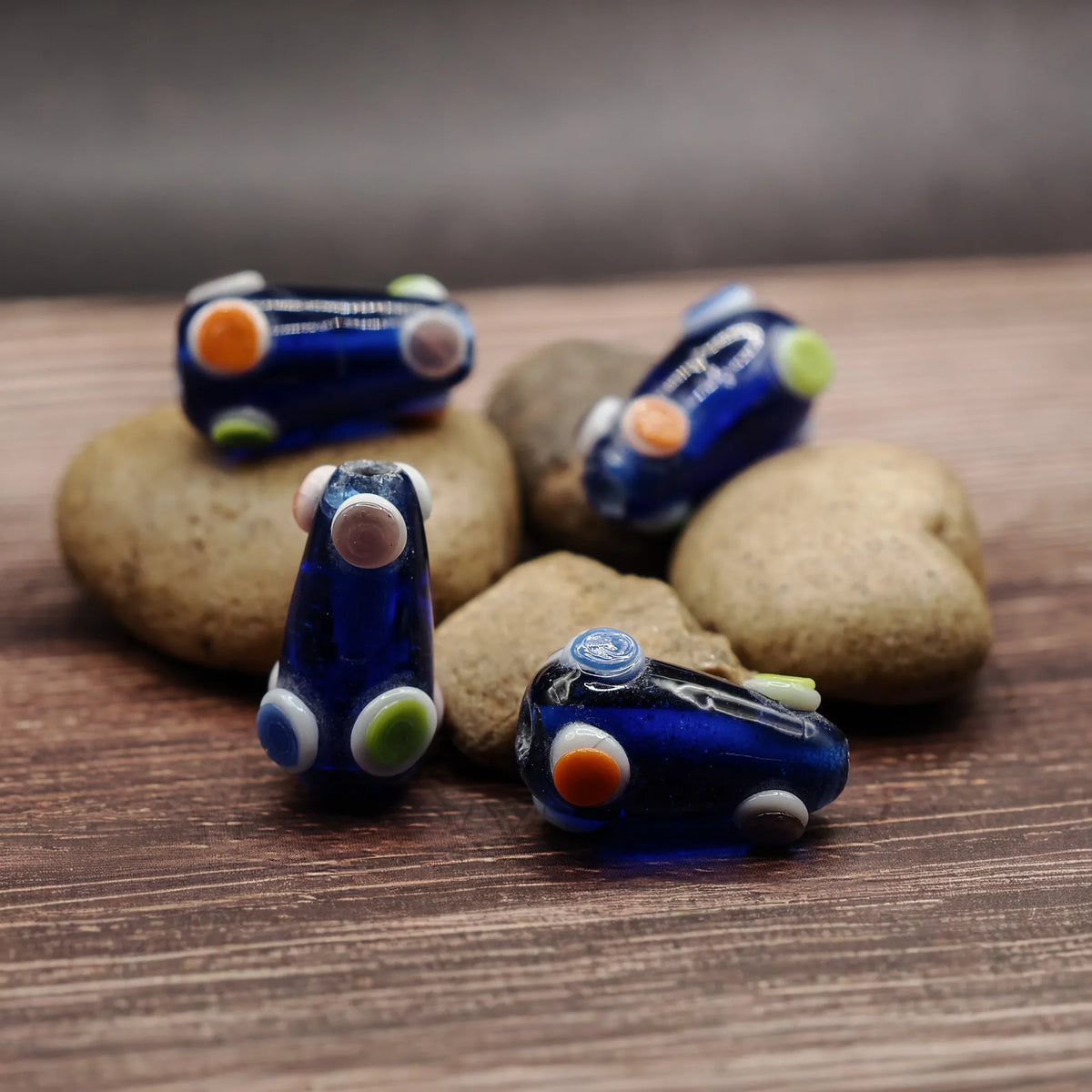 Blue, cone-shaped bead with dots – dark blue glass bead with dots in orange, white and green