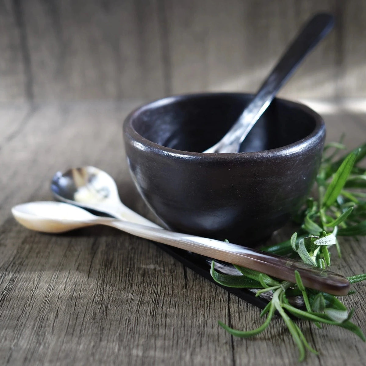 Långtesked i organisk ko-horn, liggande i svart keramik-skål med rosmarin