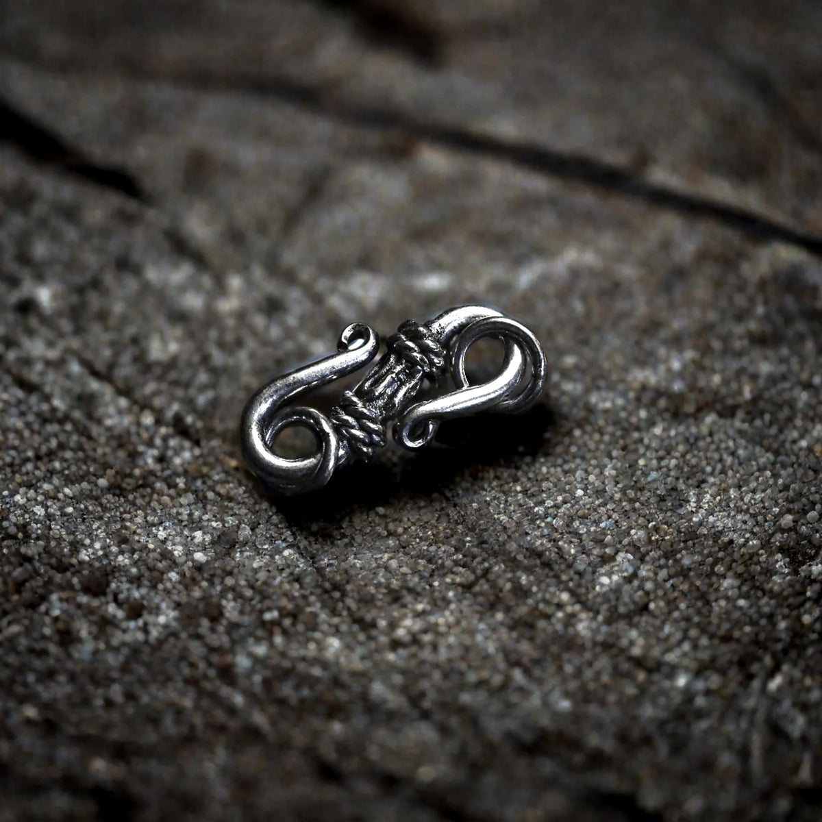 Smycklås i polerad silver med ornamental spiralmönster och filigranarbete. Dekorativt smycklås för halsband eller armband.