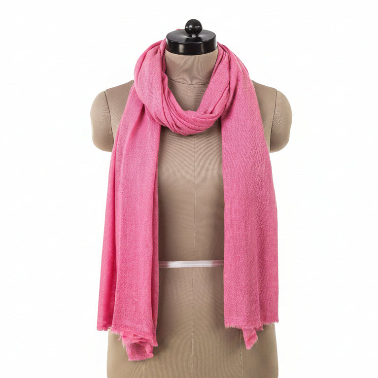Old-pink cashmere shawl folded around shoulders on a tailor's form, showing soft pink color and elegant draping