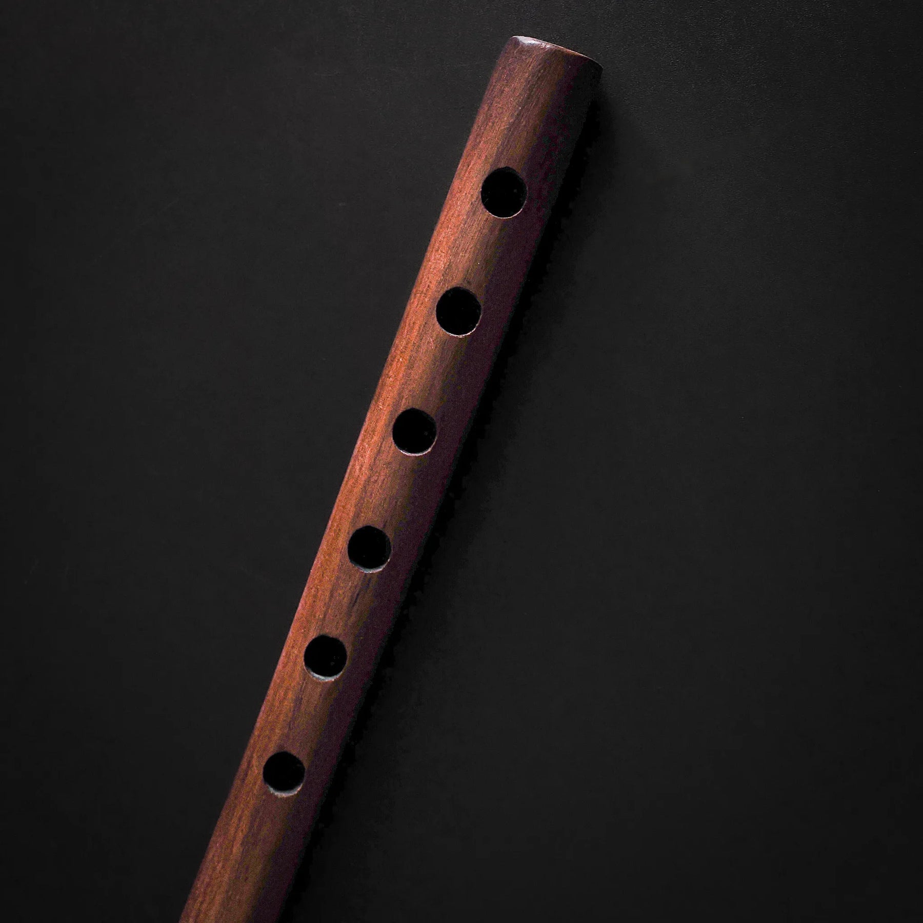 Wooden flute toy with decorative bottom ring, full vertical view