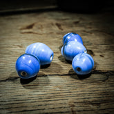 Blue elongated bead, Ribe – glossy bead with hints of golden brown and white