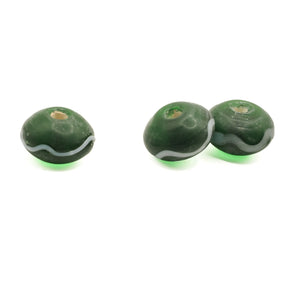 Green glass bead Birka – three beads from diagonally above, hole and white wave decoration visible