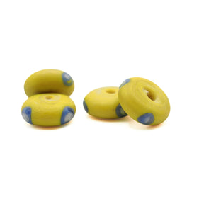 Yellow glass bead Ribe – four beads in a group, two resting on edge, blue eyes with white centre