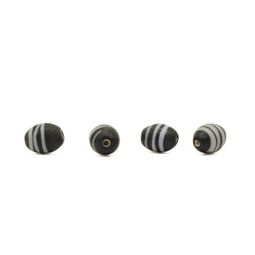 Black glass bead Gotland – four beads in a row, two facing the camera with the hole and two from the side