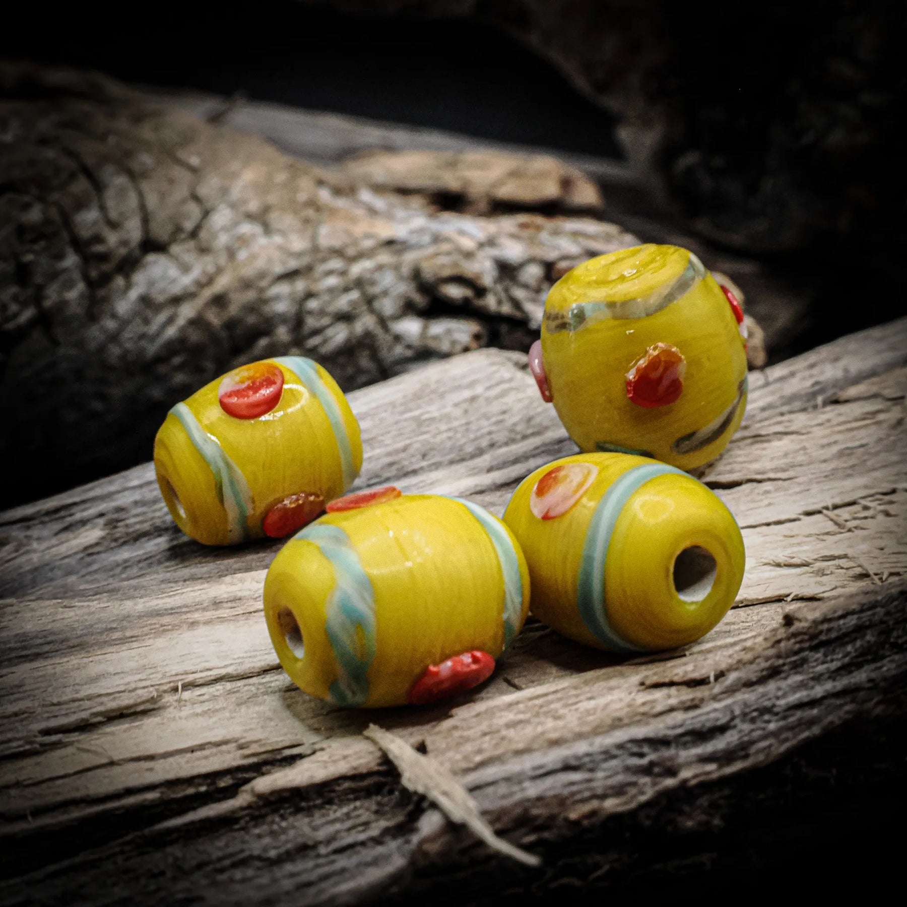Yellow glass bead Birka – four beads with red dots and blue-green bands, holes visible