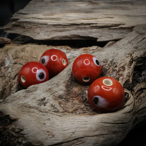 Red glass bead Birka – four beads with white eyes and visible holes, seen from different directions