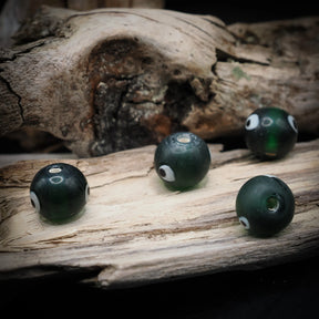 Green glass bead Birka – four beads with white eyes and holes, seen from different angles