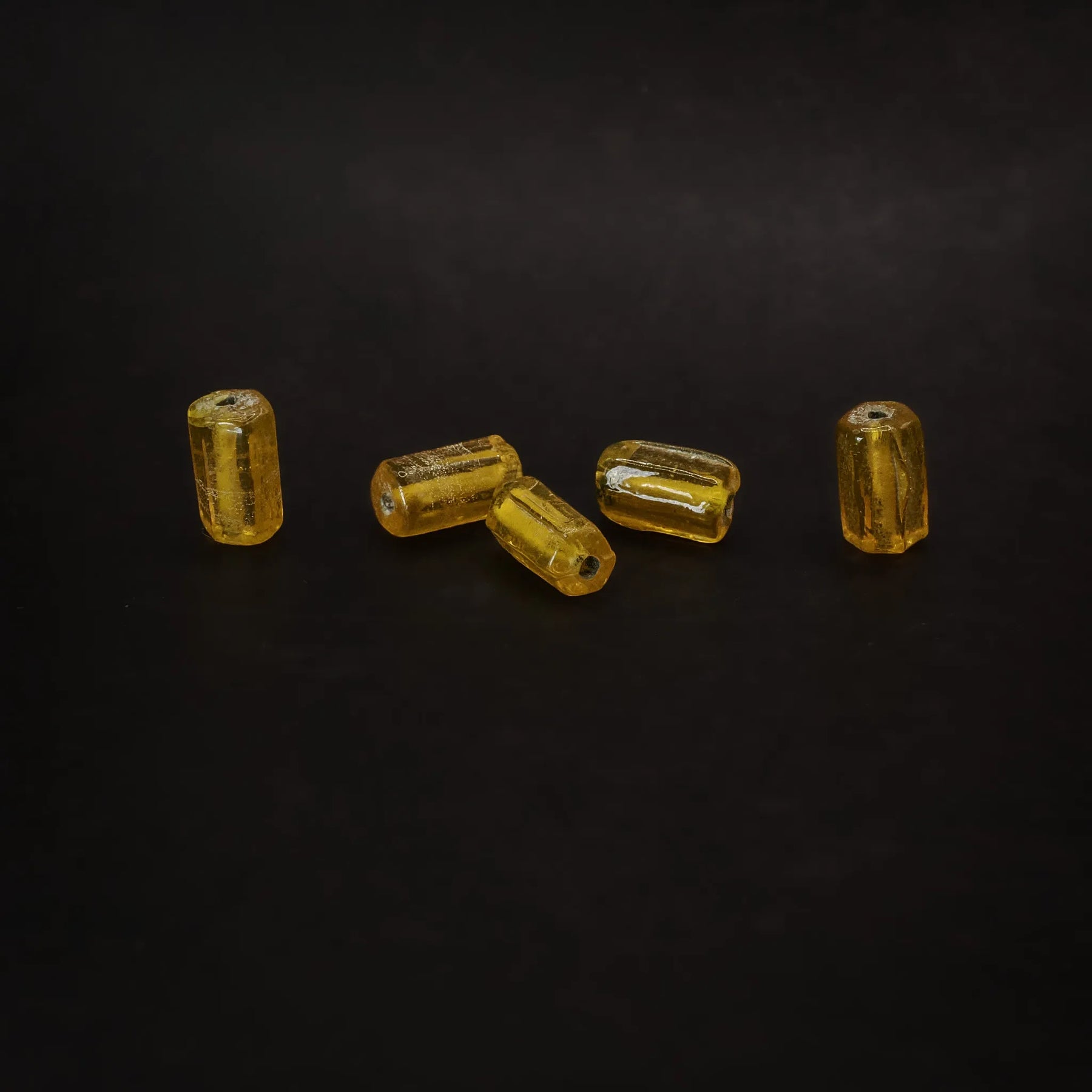 Avlång mörkgul glaspärla