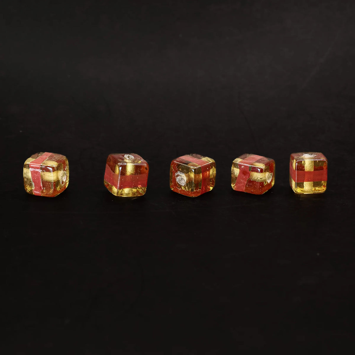 Kubisk mörkgul glaspärla