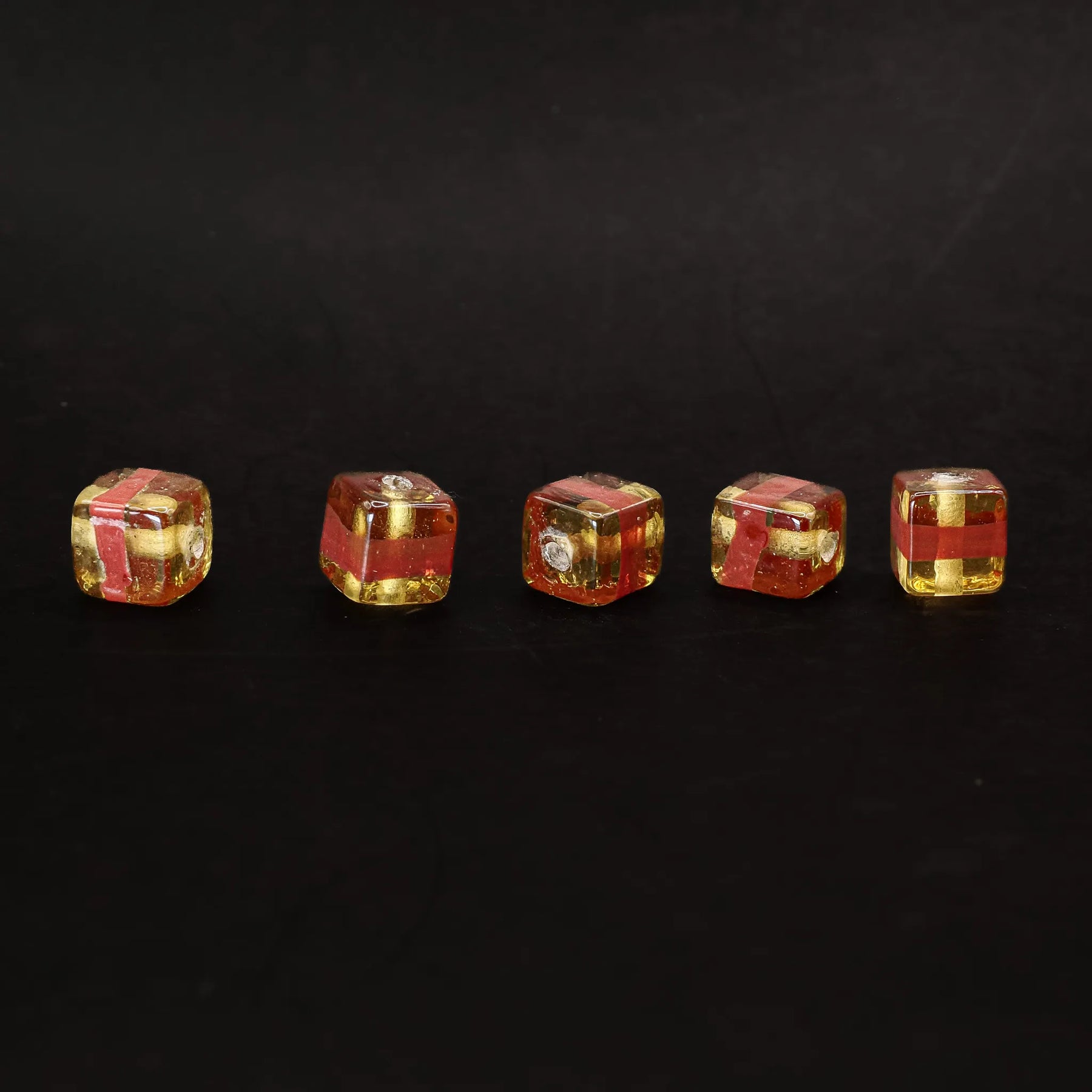 Kubisk mörkgul glaspärla