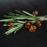 Kubisk mörkgul glaspärla