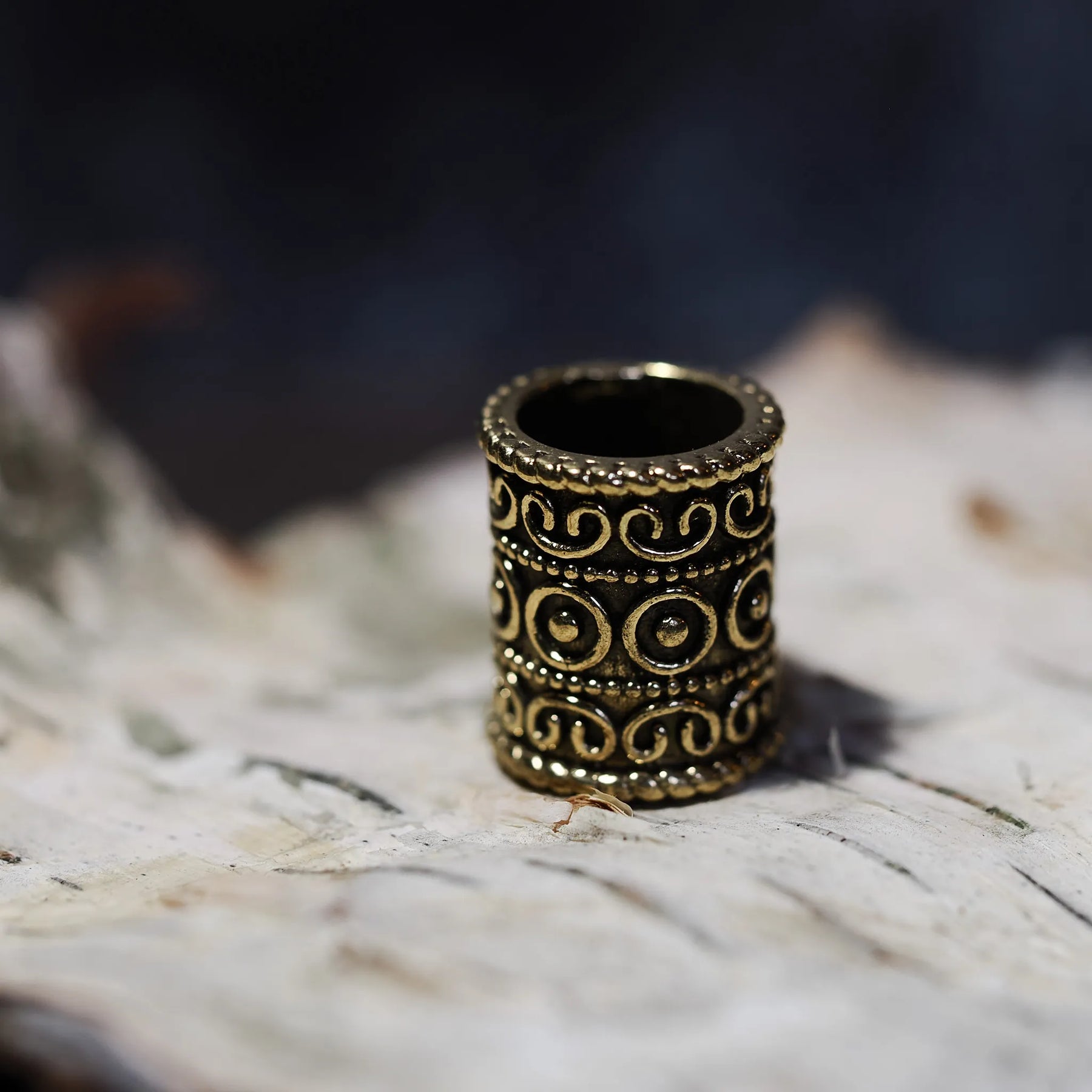 Golden polished brass beard bead with scrollwork ornament and circular embossed design