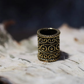 Golden polished brass beard bead with scrollwork ornament and circular embossed design