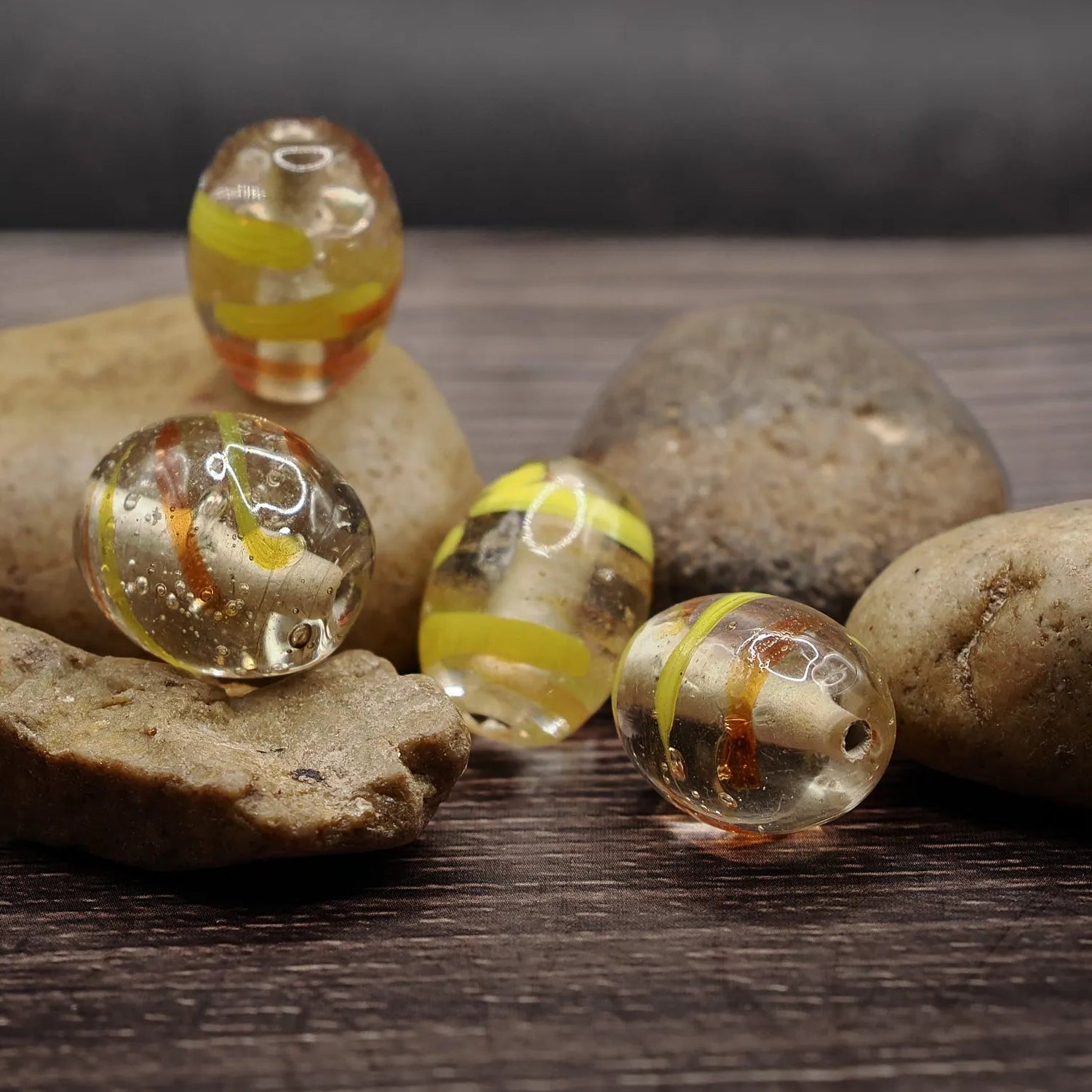Oval glass bead in clear glass with yellow accents