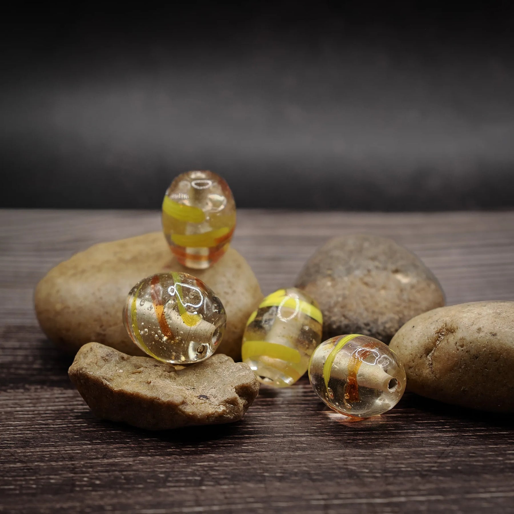 Oval glass bead in clear glass with yellow accents