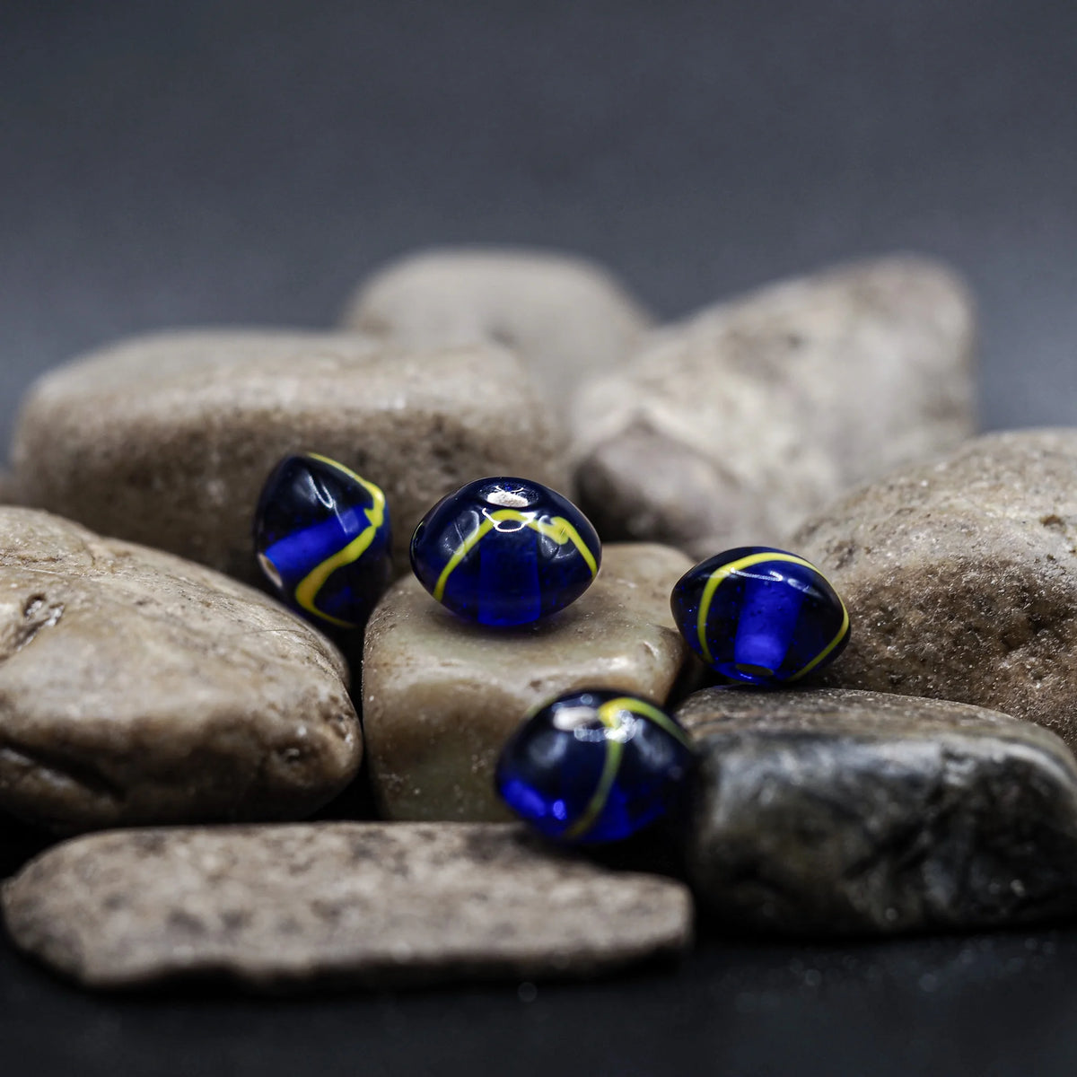 Blue glass bead with yellow decoration