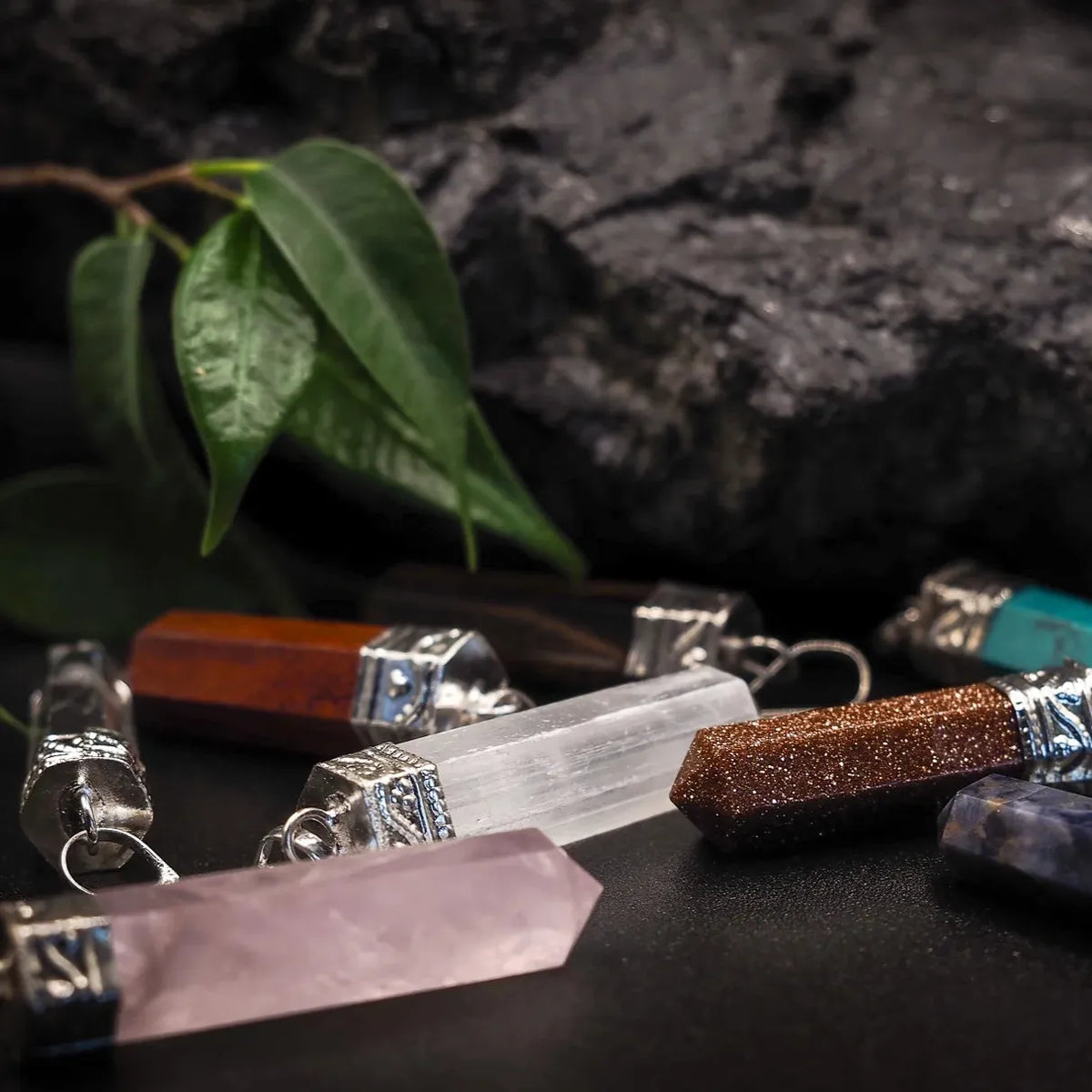 Stone pendant, "Turquoise" – among several stone pendants in different colors, group shot with a green leaf
