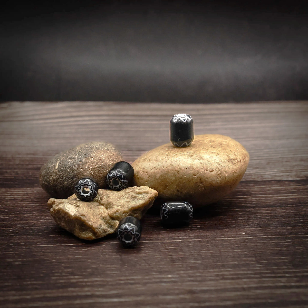 Svart, avlång glaspärla med mönster