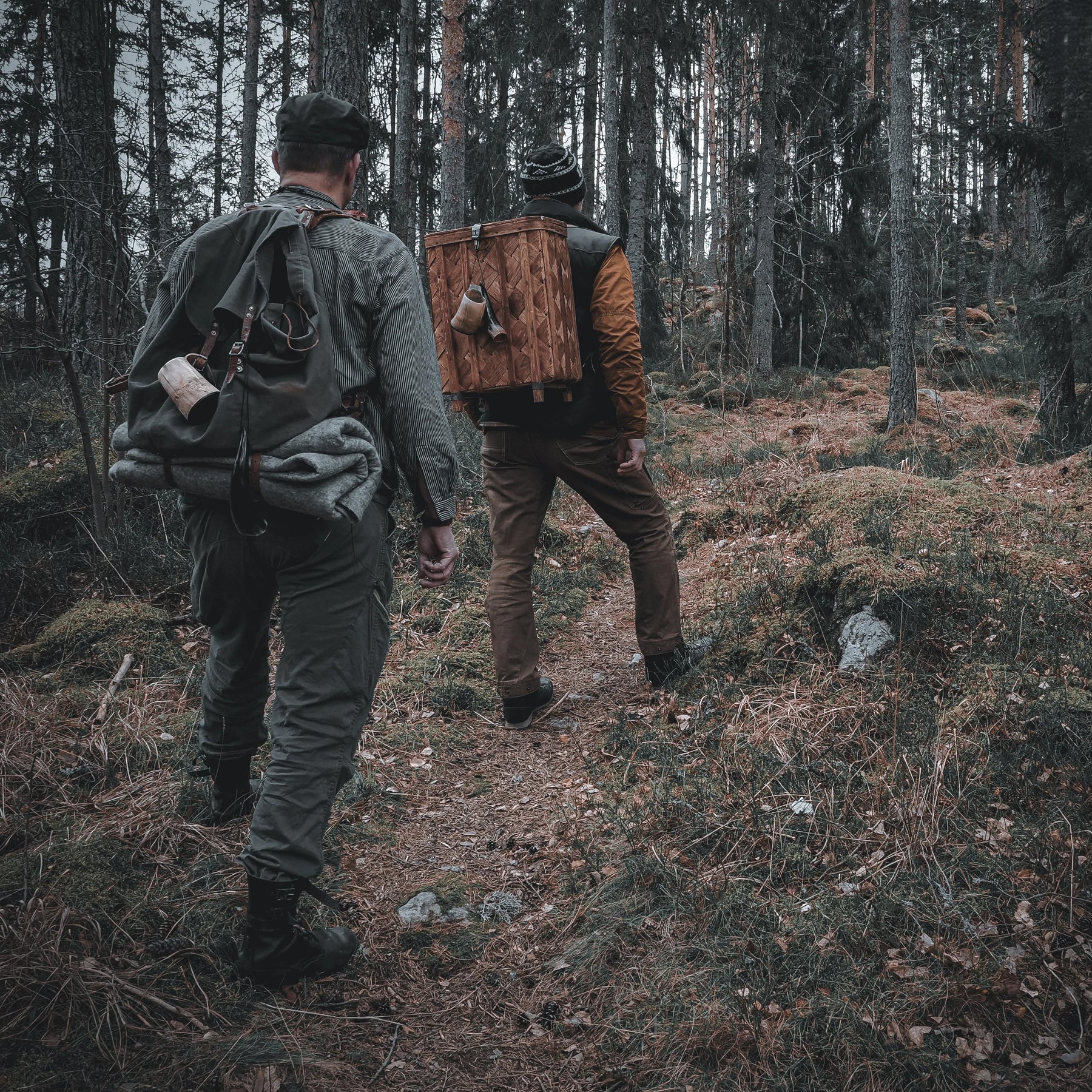 Felted wool blanket, sleeping mat – rolled up and strapped to a backpack in forest terrain