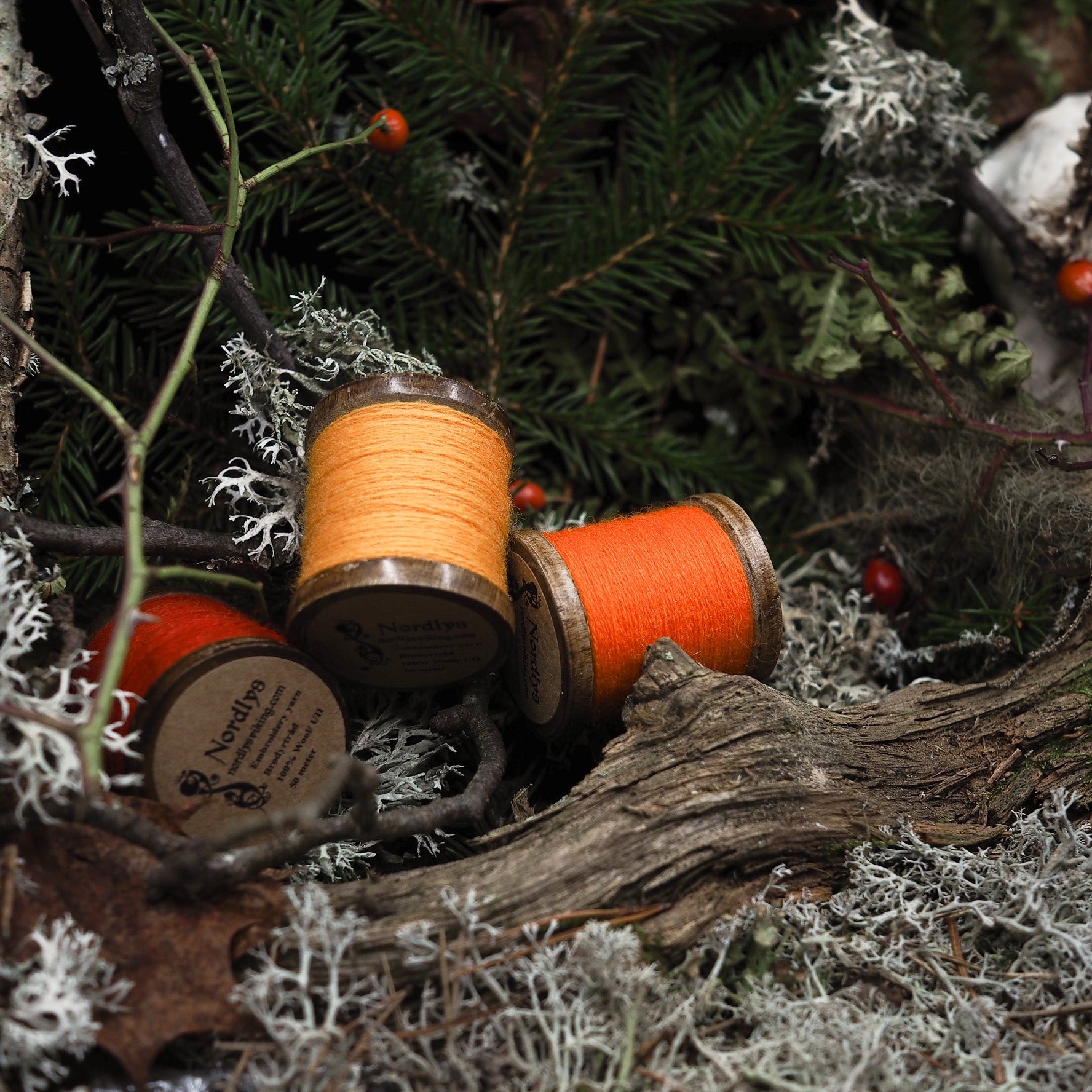 En traspola med gyllengul 100% ullbrodörtråd på mörk träyta, visar naturlig träkonstruktion och finare väv