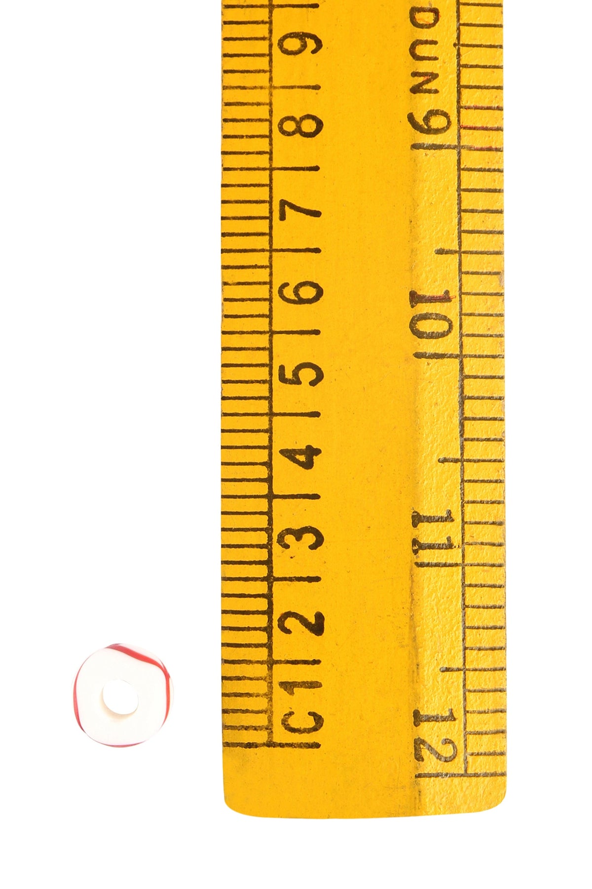 White glass bead with decoration, Vega – next to a ruler, the bead measures approx. 1 cm